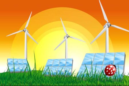 Panels with solar cells and wind generators on a green field with blue sky stock photo