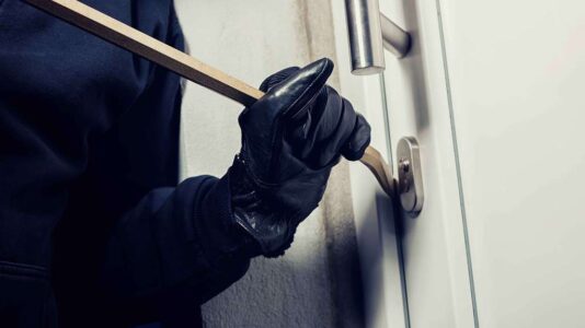burglar-using-crowbar-break-home-door-night burglar-using-crowbar-break-home-door-night