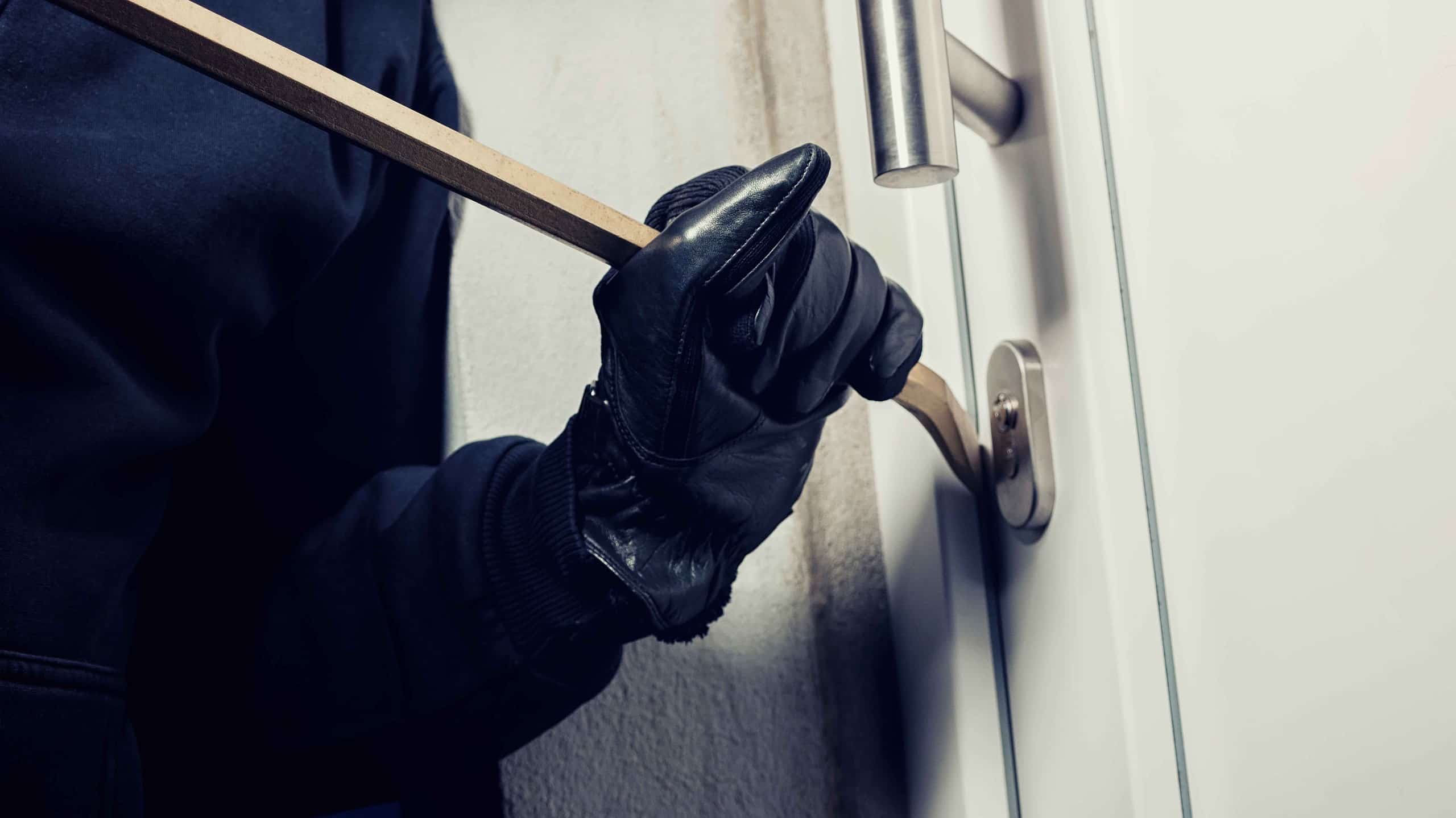 burglar-using-crowbar-break-home-door-night