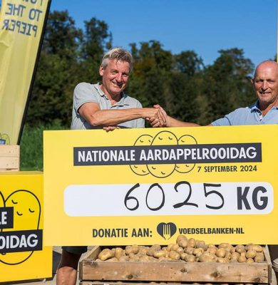 Dick Hylkema, directeur van de Nederlandse Aardappel Organisatie, overhandigt de cheque van 6050 kilo aardappelen aan Kees Bos van de Voedselbank bij deelnemende teler Lodders Landbouw in Dronten.
