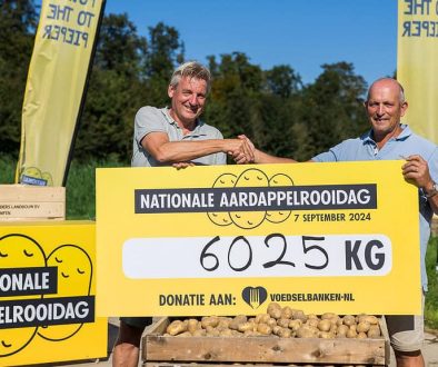 Dick Hylkema, directeur van de Nederlandse Aardappel Organisatie, overhandigt de cheque van 6050 kilo aardappelen aan Kees Bos van de Voedselbank bij deelnemende teler Lodders Landbouw in Dronten.