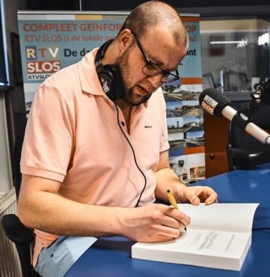 Tim de vries zet handtekening in zijn boek' Vive le Tour, Vive les Femmes' ©Yannick van den Dijssel