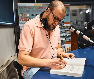 Tim de vries zet handtekening in zijn boek' Vive le Tour, Vive les Femmes' ©Yannick van den Dijssel