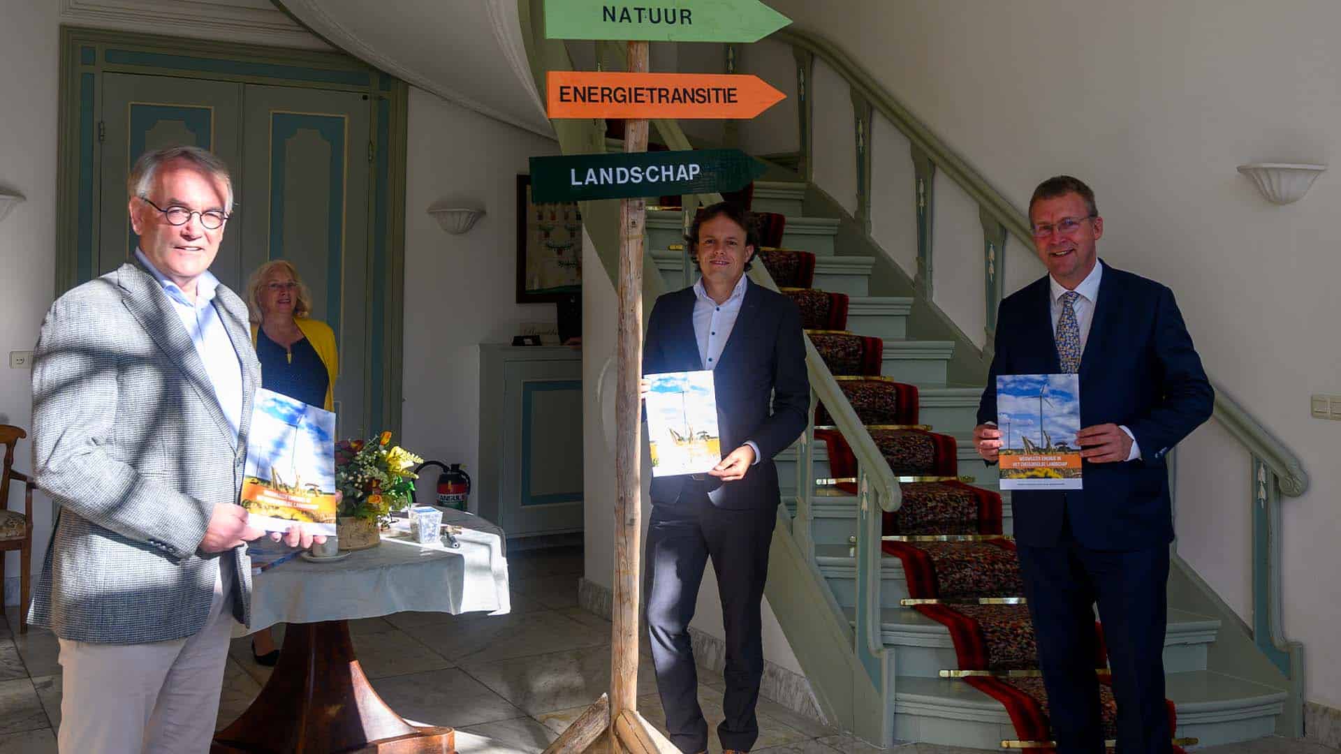 De drie bestuurders met en bij de wegwijzer