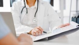 young-asia-female-doctor-white-medical-uniform-using-clipboard-is-delivering-great-news-talk-discuss-results