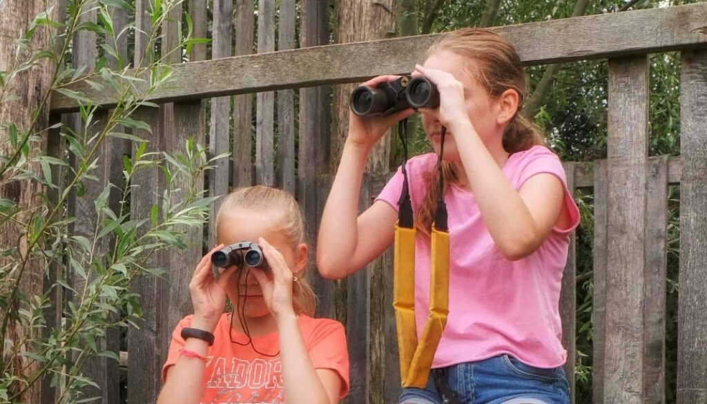 NAMO110830 Laurence Delderfield zomermeisje speelnatuur verrekijker staand