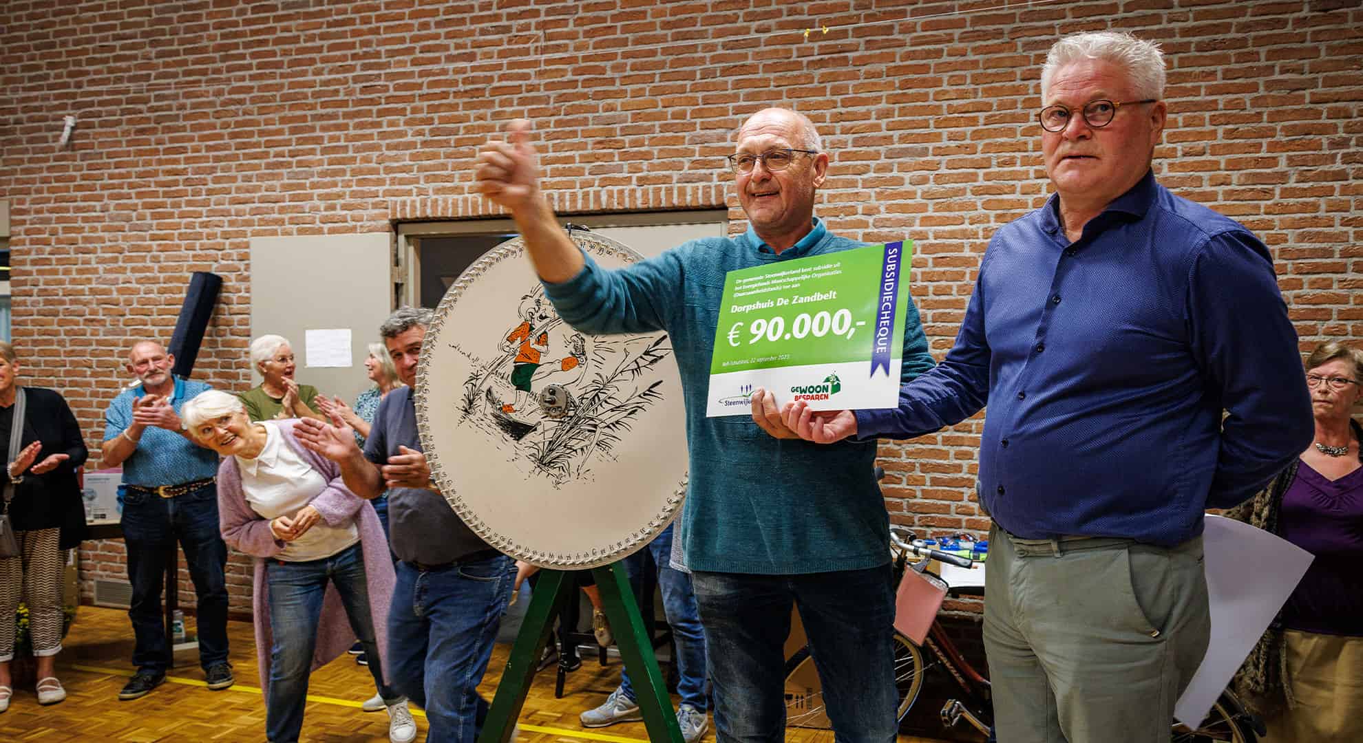 Wethouder Marcel Scheringa biedt cheque aan, foto Wilbert Bijzitter