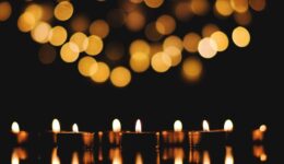 brandende-kaarsen-met-feestelijke-bokeh-op-zwarte-achtergrond-vakantieconcept-het-concept-van-gebed-hoop