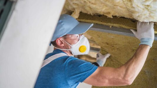 man-insulating-house