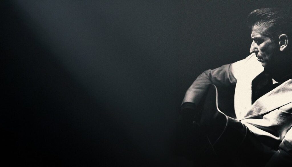 Gitarist in zwarte en witte jas met snaren, zwart-wit foto, muziek, entertainment, RTV SLOS.