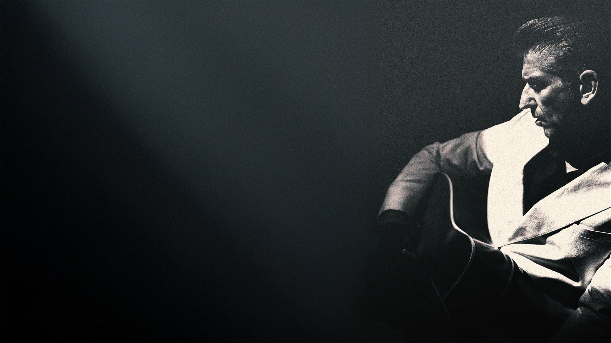 Gitarist in zwarte en witte jas met snaren, zwart-wit foto, muziek, entertainment, RTV SLOS.