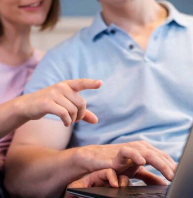 Klantenservice medewerker en klant werken samen met laptop, informele werksituatie, moderne kantoorsetting, technologiegebruik, focus op digitale communicatie, professionele samenwerking, teamwerk, klantgerichte service, online ondersteuning.