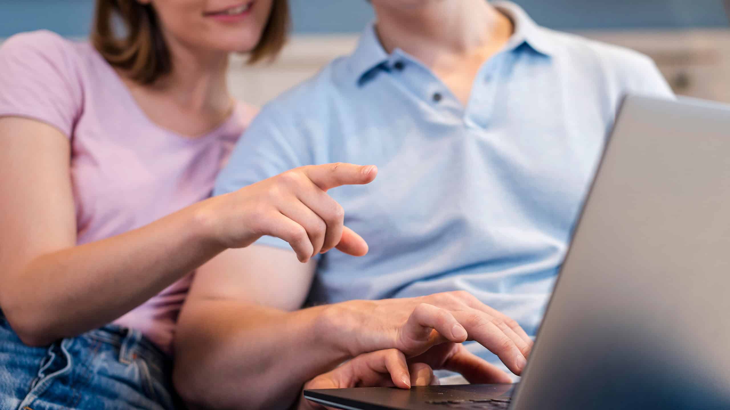 Klantenservice medewerker en klant werken samen met laptop, informele werksituatie, moderne kantoorsetting, technologiegebruik, focus op digitale communicatie, professionele samenwerking, teamwerk, klantgerichte service, online ondersteuning.