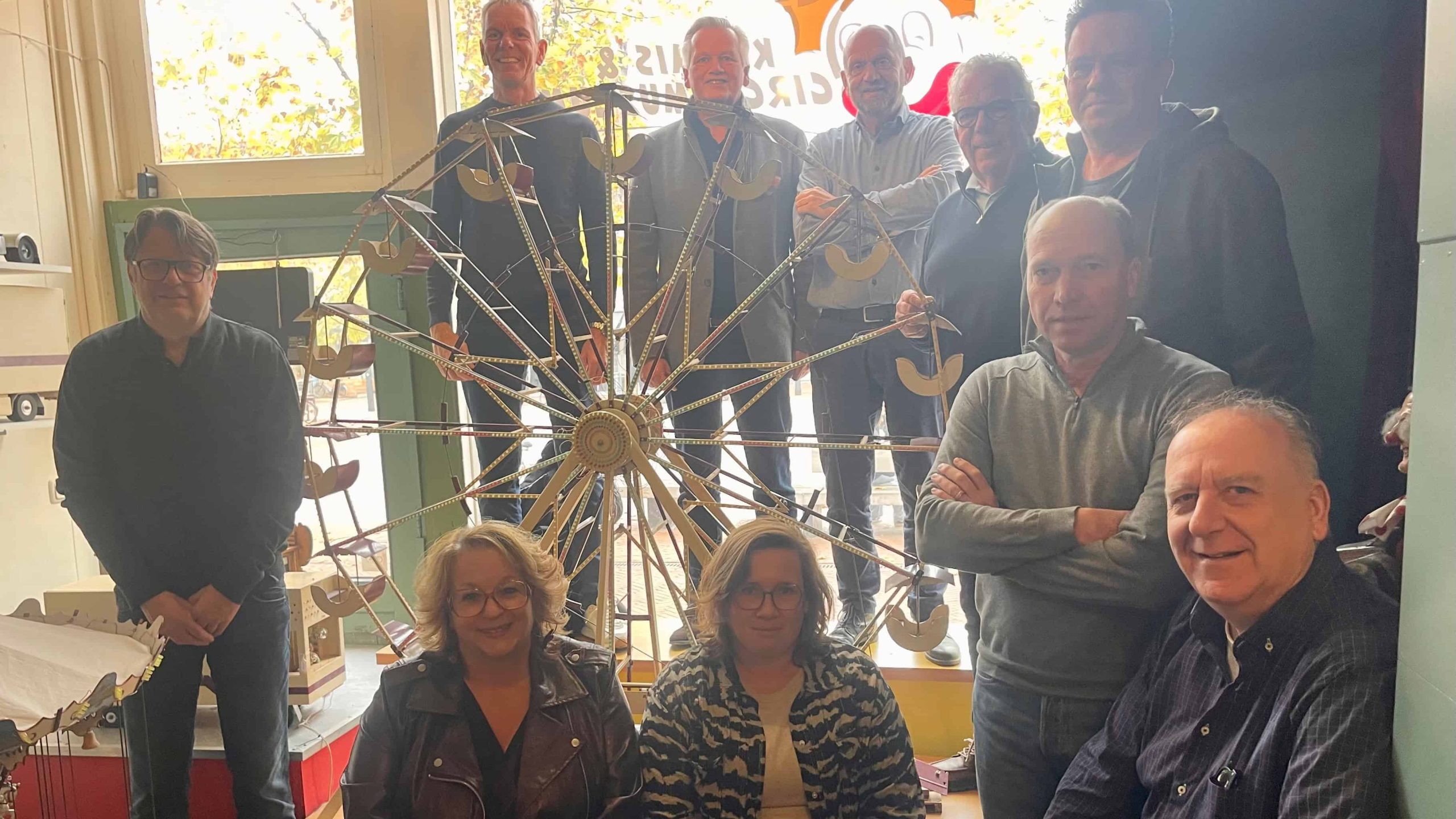 Sponsoren, gemeente en vertegenwoordigers van Steenwijk Vestingstad bij het reuzenrad in het voormalige Kermis & Circusmuseum - foto Steenwijk Vestingstad