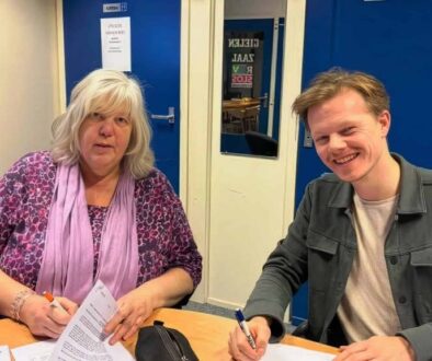 Aukje Oppersma (secretaris Omroep Odrie, namens de samenwerkende lokale omroepen) en Joey Teekamp tekenen de opdrachtovereenkomst. Foto: Streekomroep De Werven