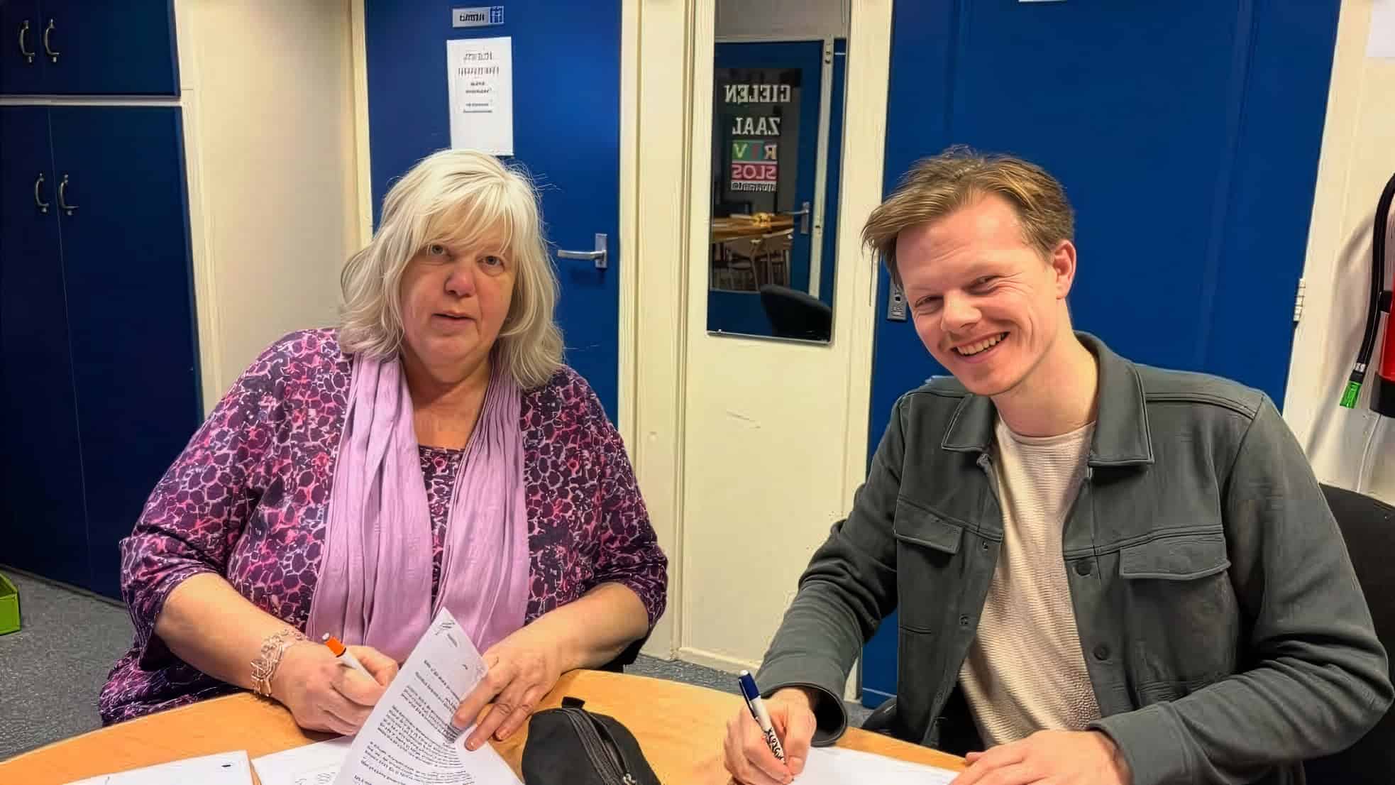 Aukje Oppersma (secretaris Omroep Odrie, namens de samenwerkende lokale omroepen) en Joey Teekamp tekenen de opdrachtovereenkomst. Foto: Streekomroep De Werven
