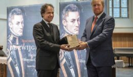 Chris van Houts reikt Van Stipriaan het eerste exemplaar van zijn boek over Willem van Oranje uit aan de Koning. foto aangeleverd