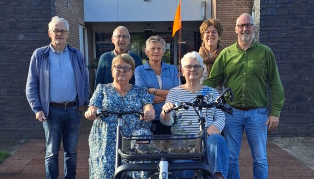 Bestuursleden Gerard Meijerink, Yme van der Valk, Lydia Schot, Marieke Pit, Marcel de Jong, op de duofiets vlnr: Alie Jongschaap en Loes Frissen (foto aangeleverd)