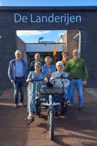 Bestuursleden Gerard Meijerink, Yme van der Valk, Lydia Schot, Marieke Pit, Marcel de Jong, op de duofiets vlnr: Alie Jongschaap en Loes Frissen (foto aangeleverd)
